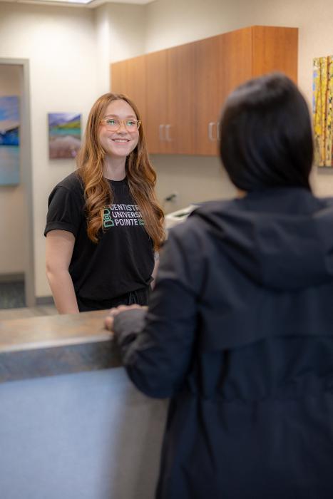 Front desk lady talking to patient at dentistry @ university pointe, west chester oh