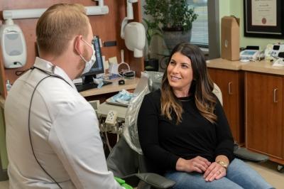Woman with brown hair talking to dentist, west chester oh