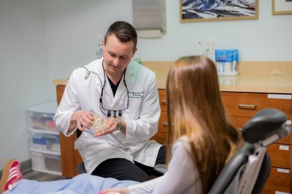 Dr. Mitchell showing a teeth mold to a patient, west chester oh