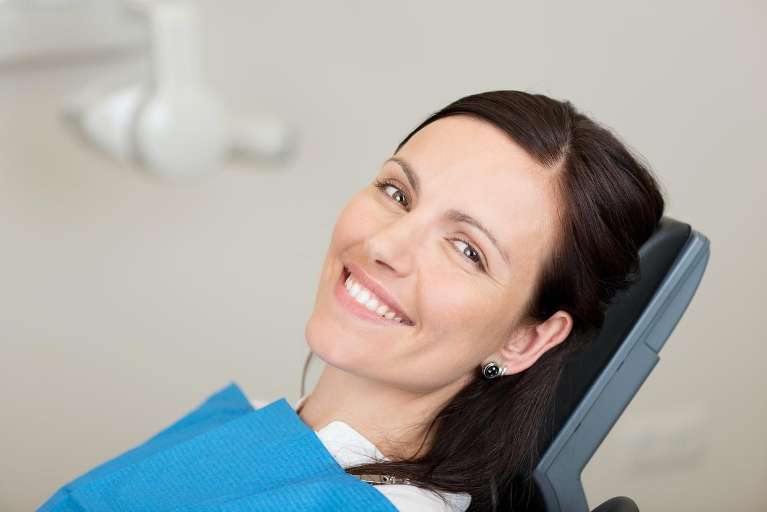 Woman with brown hair smiling in dental chair, west chester oh