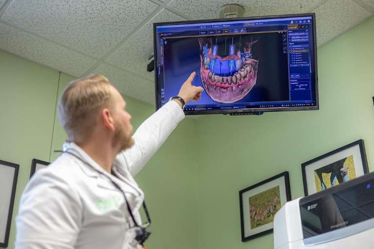 Dr. Caesar using a tv in a treatment room at dentistry @ university pointe in west chester, oh